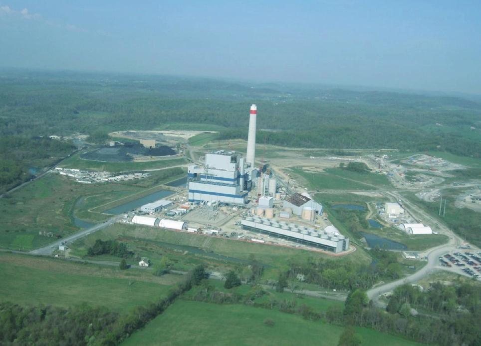 An aerial view of a large power plant surrounded by trees and grass.