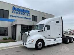 A white semi truck is parked in front of a building.