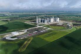 An aerial view of a farm with silos in the middle of a field.