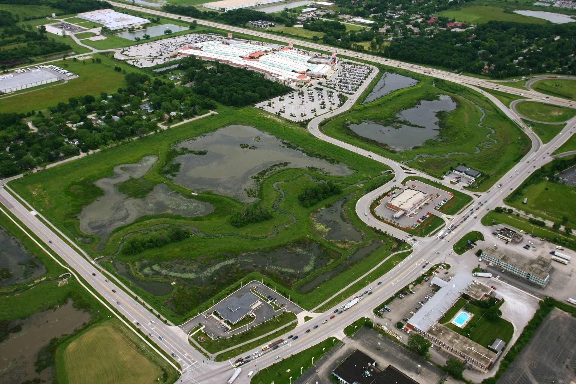An aerial view of a residential area with a shopping mall in the background