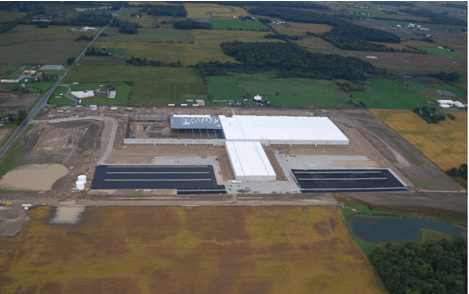 An aerial view of a large building in the middle of a field