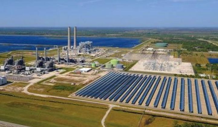 An aerial view of a power plant with solar panels in the foreground.