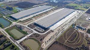 An aerial view of a large warehouse surrounded by fields.