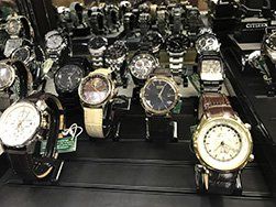 Display case of various wristwatches with different band styles and watch faces.