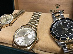 Three gold Rolex watches in a box, a close-up with focus on the watches.