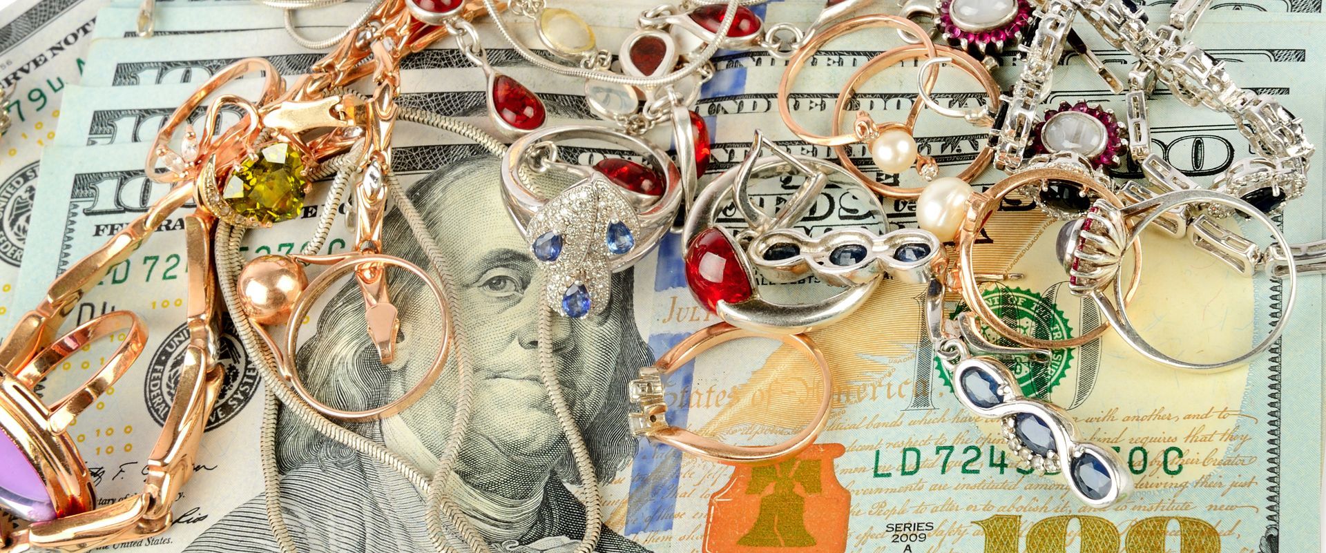 A collection of sparkling jewelry and stacks of cash, highlighting cash for diamonds.