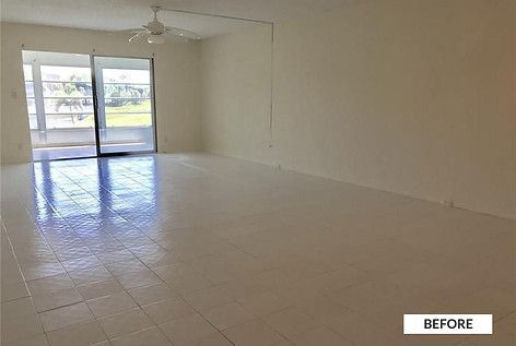 Empty, pale-walled room with sliding glass door and white tiled floor;