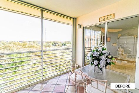 Balcony with glass table, chairs, flowers, and outdoor view;