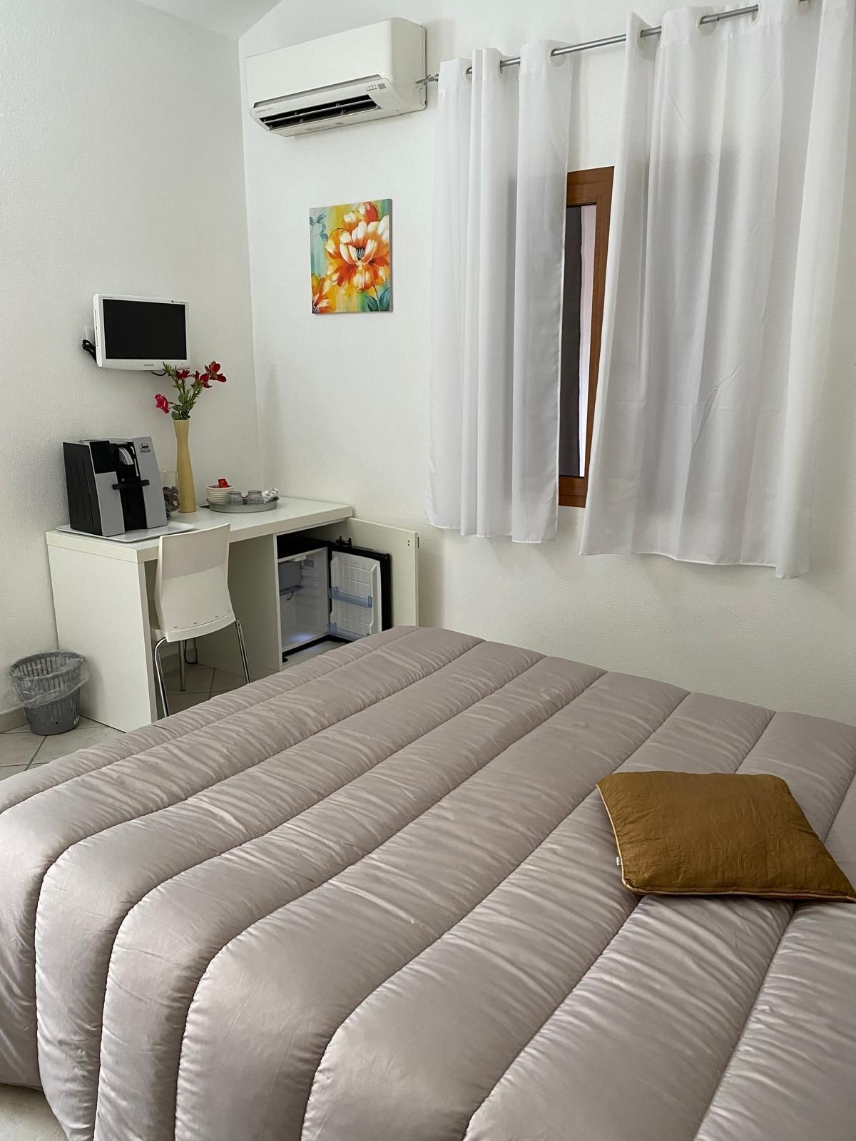 Una camera da letto essenziale con due letti singoli, copriletti a fantasia e un armadio in legno.