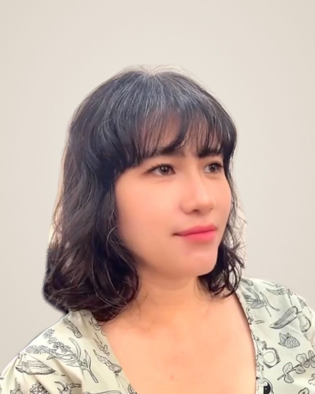 Woman with shoulder-length dark hair, soft bangs and lifted volume at the roots after a root perm by Joanne at Kimage Salon Singapore