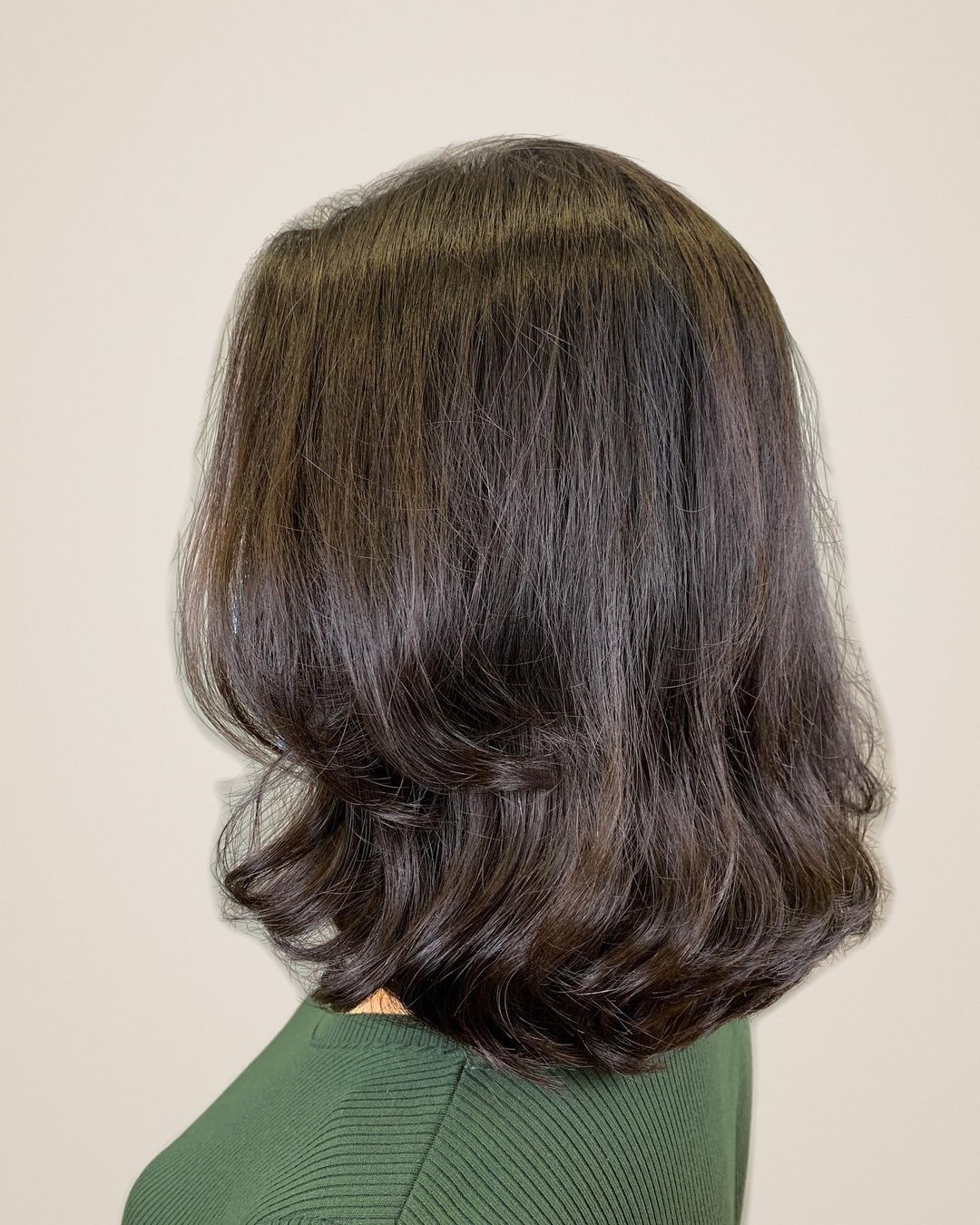 Shoulder-length dark brown hair with bouncy, glossy curled ends from a digital perm by Ann Feng at Kimage Salon Singapore