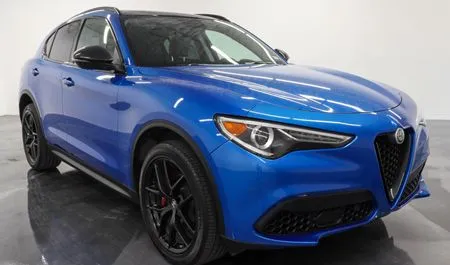 Blue Alfa Romeo SUV in a studio setting, shown from the front-left angle.