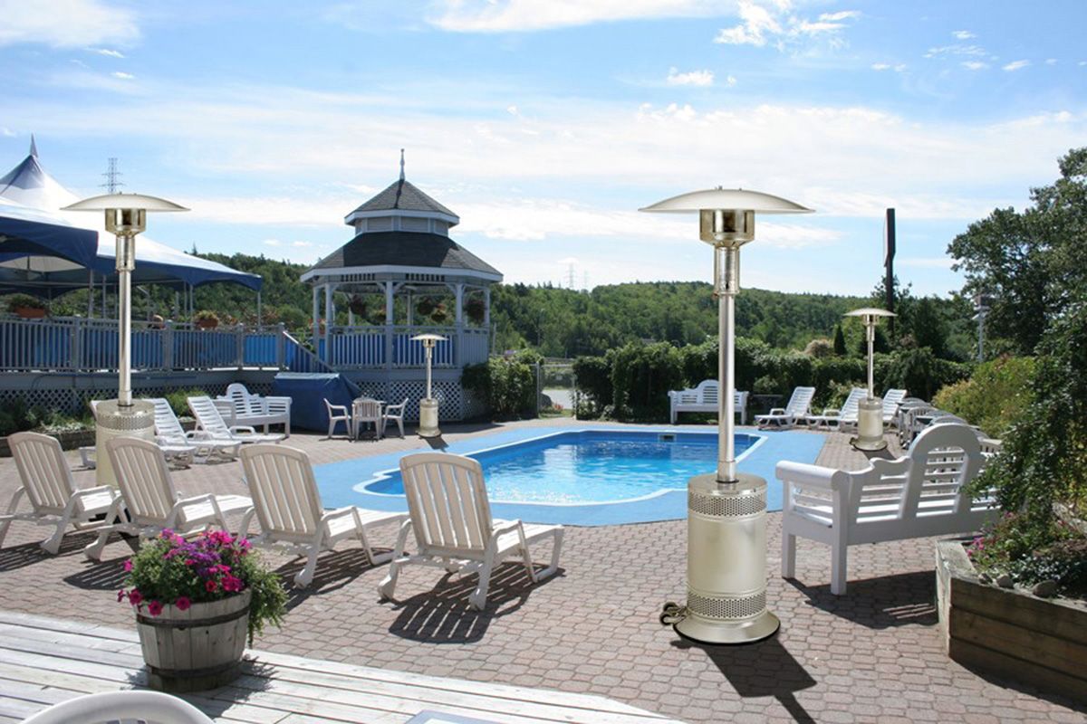 A large swimming pool with a gazebo in the background