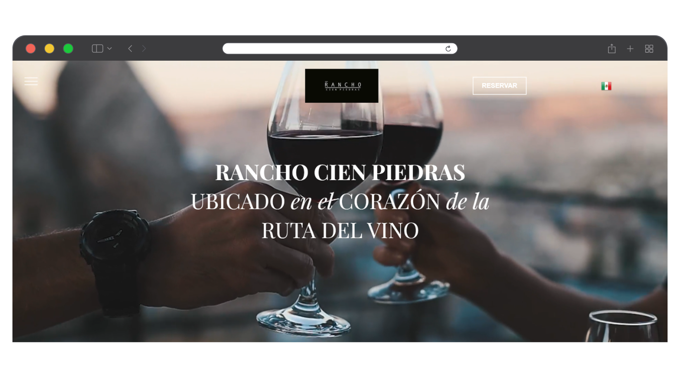 Página de inicio del sitio web de la bodega con copas de vino y titular en español sobre una escena de cata borrosa.