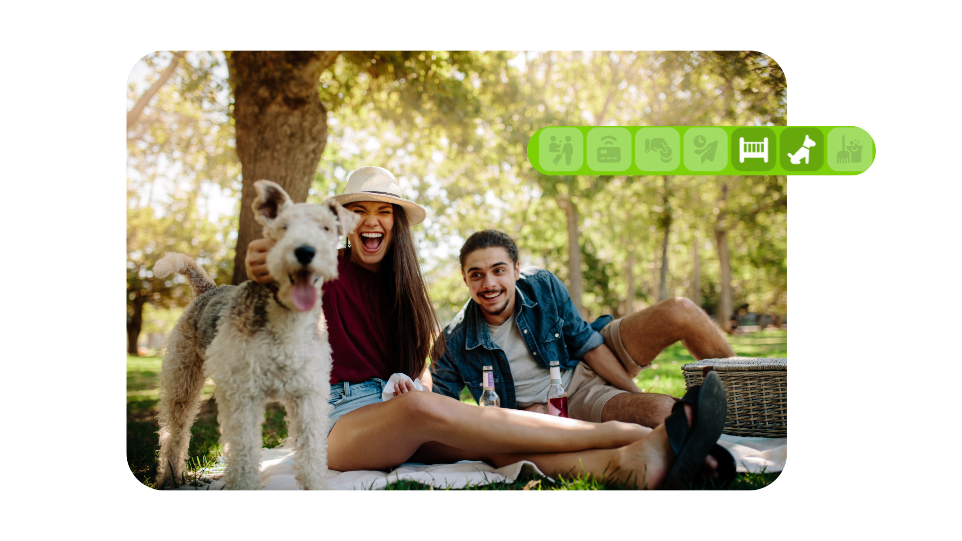 Dos personas sentadas en el césped con un perro blanco grande en un parque soleado.