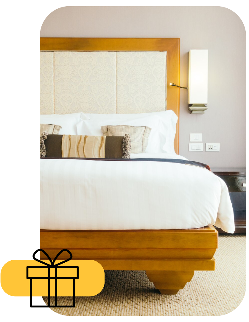 Dormitorio moderno con cama de madera, ropa de cama blanca y lámpara de pared.