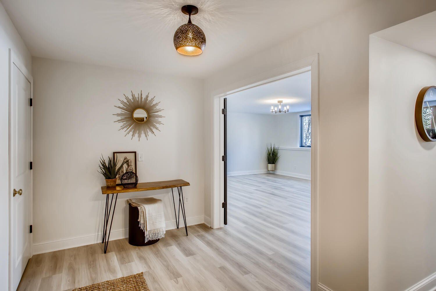 A hallway in a house with a table and a mirror on the wall.