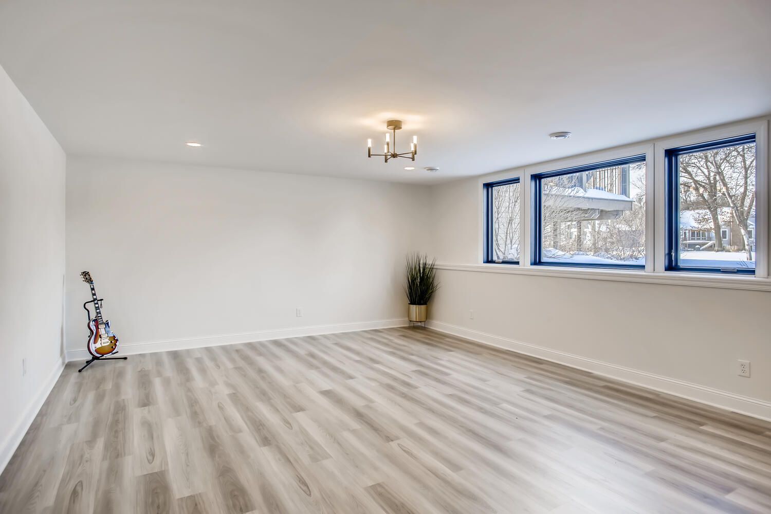 A large empty room with hardwood floors and lots of windows.
