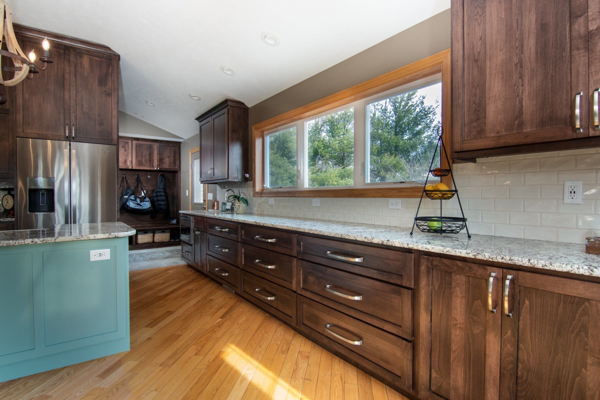 A kitchen with wooden cabinets , granite counter tops , and stainless steel appliances.