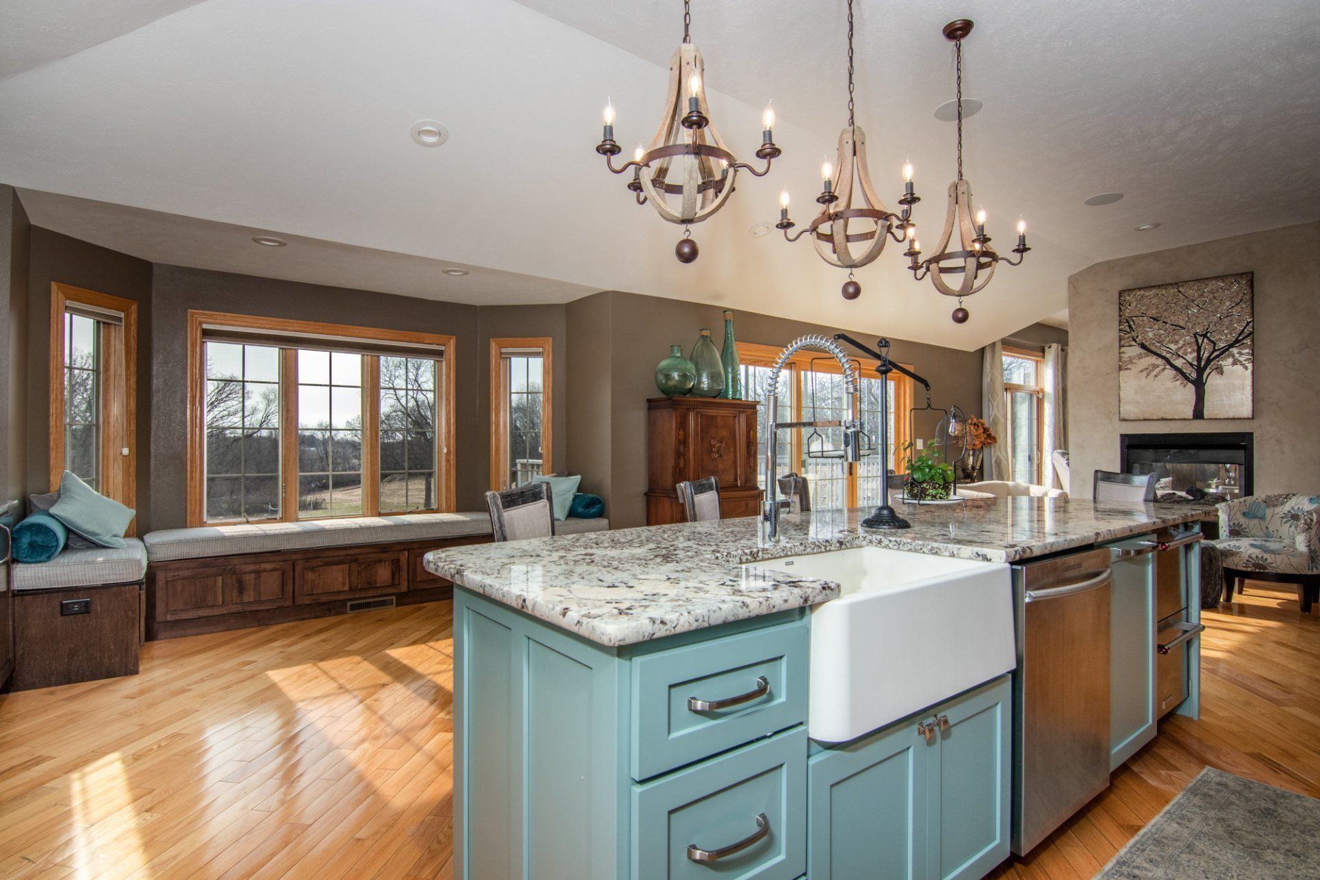 A kitchen with blue cabinets , granite counter tops , and a sink.