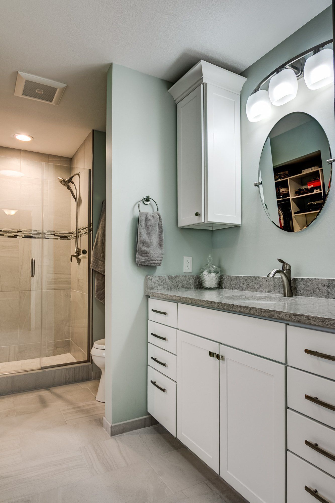 A bathroom with a sink , toilet , shower and mirror.