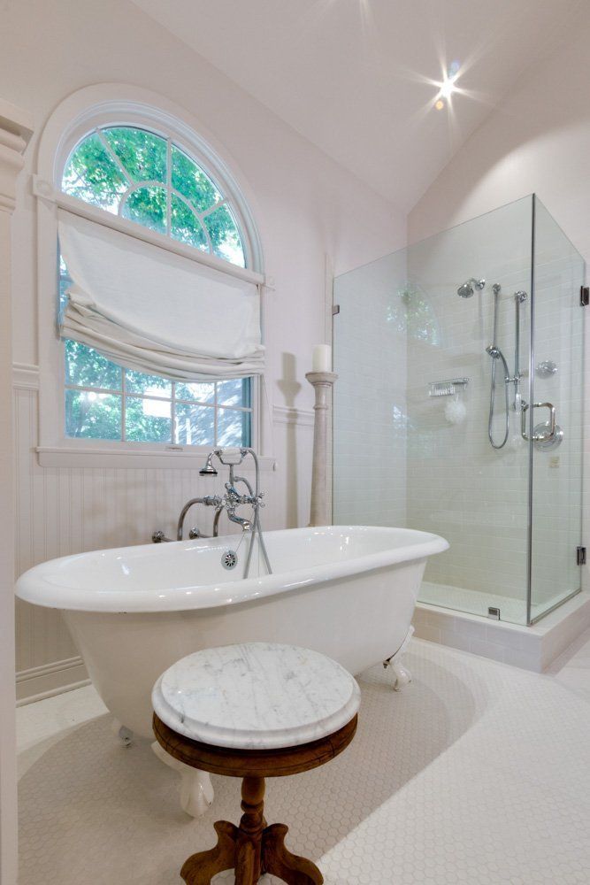 A bathroom with a claw foot tub and a walk in shower.