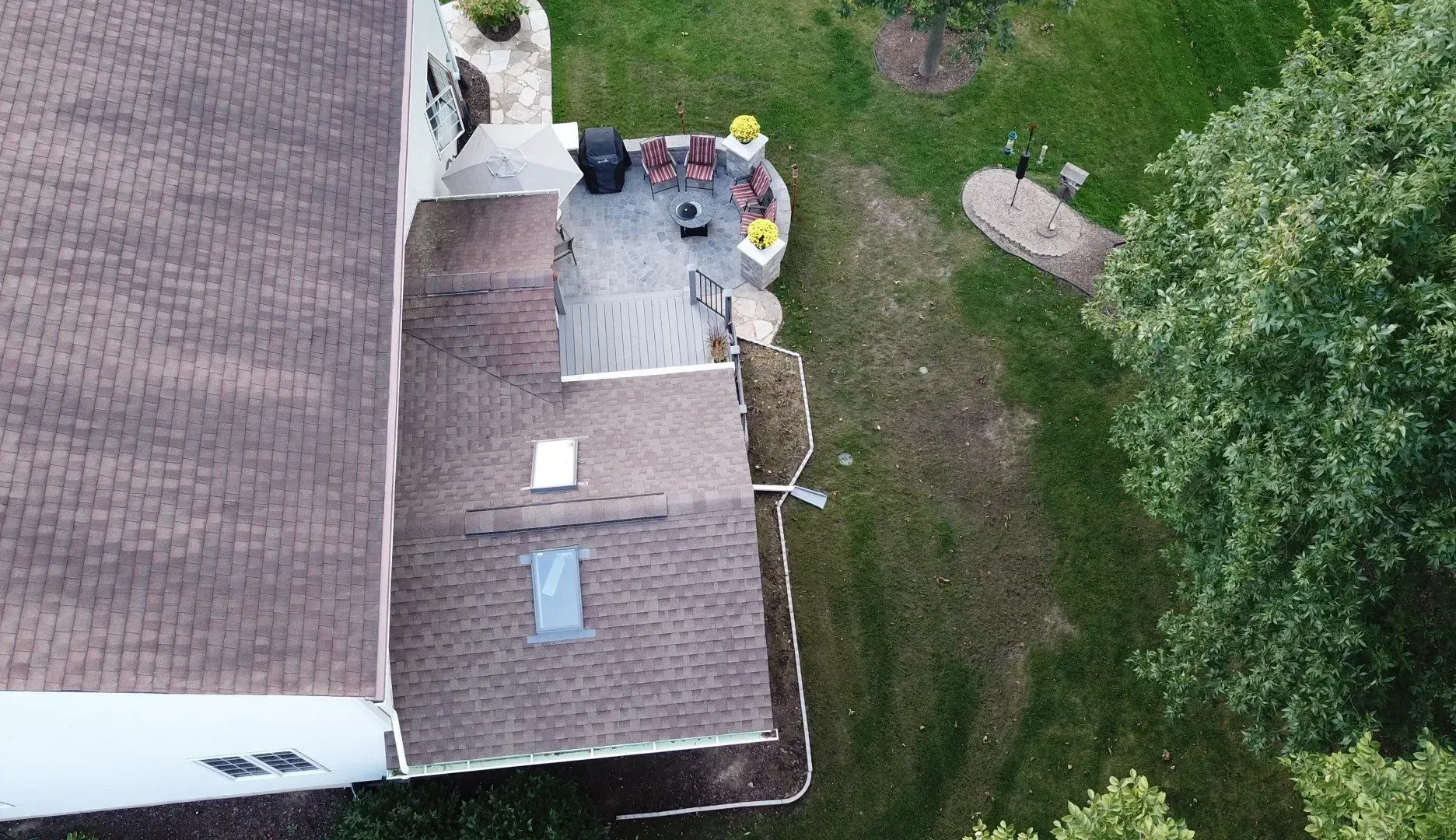 An aerial view of a house with a patio and trees in the backyard.