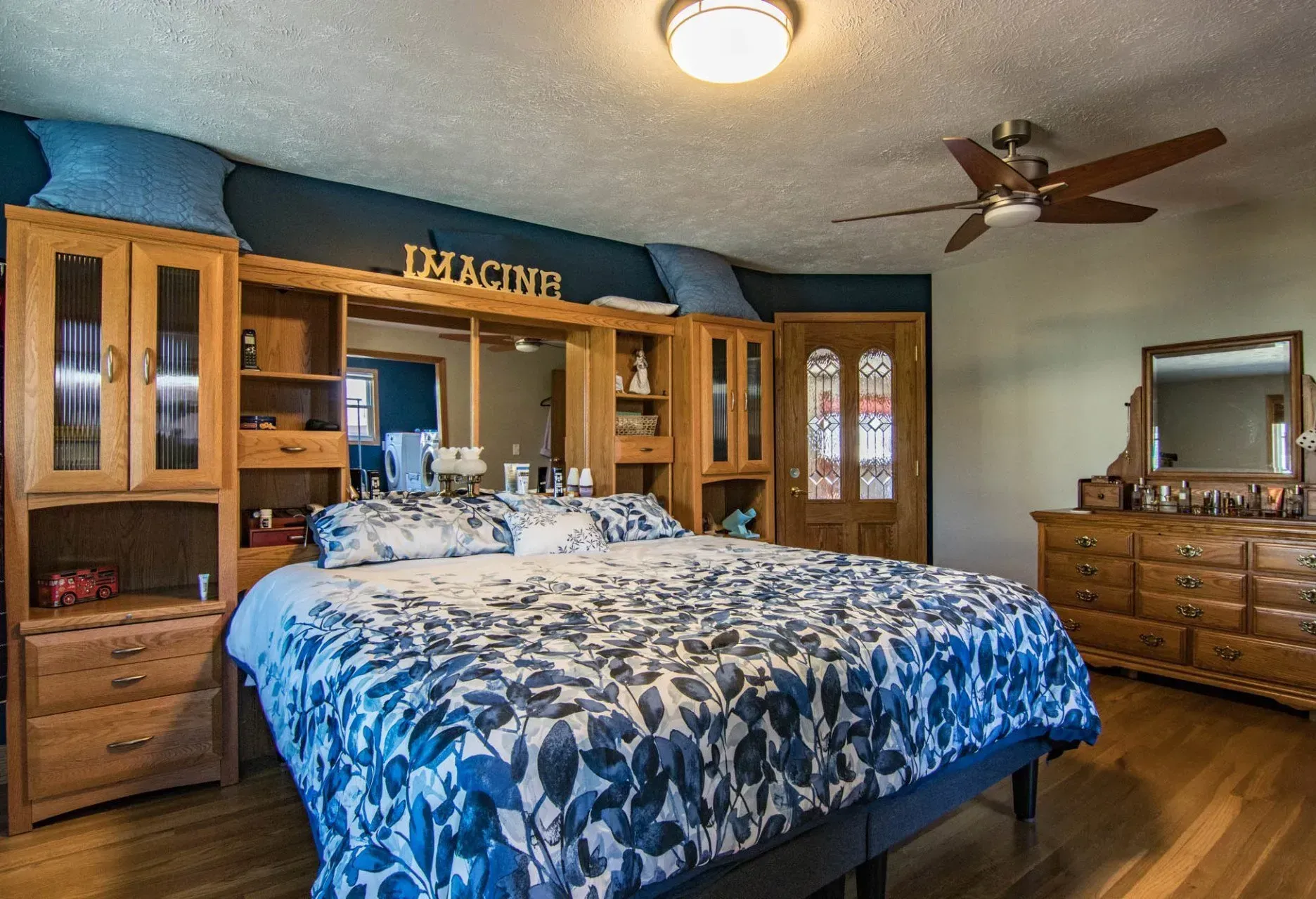 A bedroom with a large bed and a ceiling fan