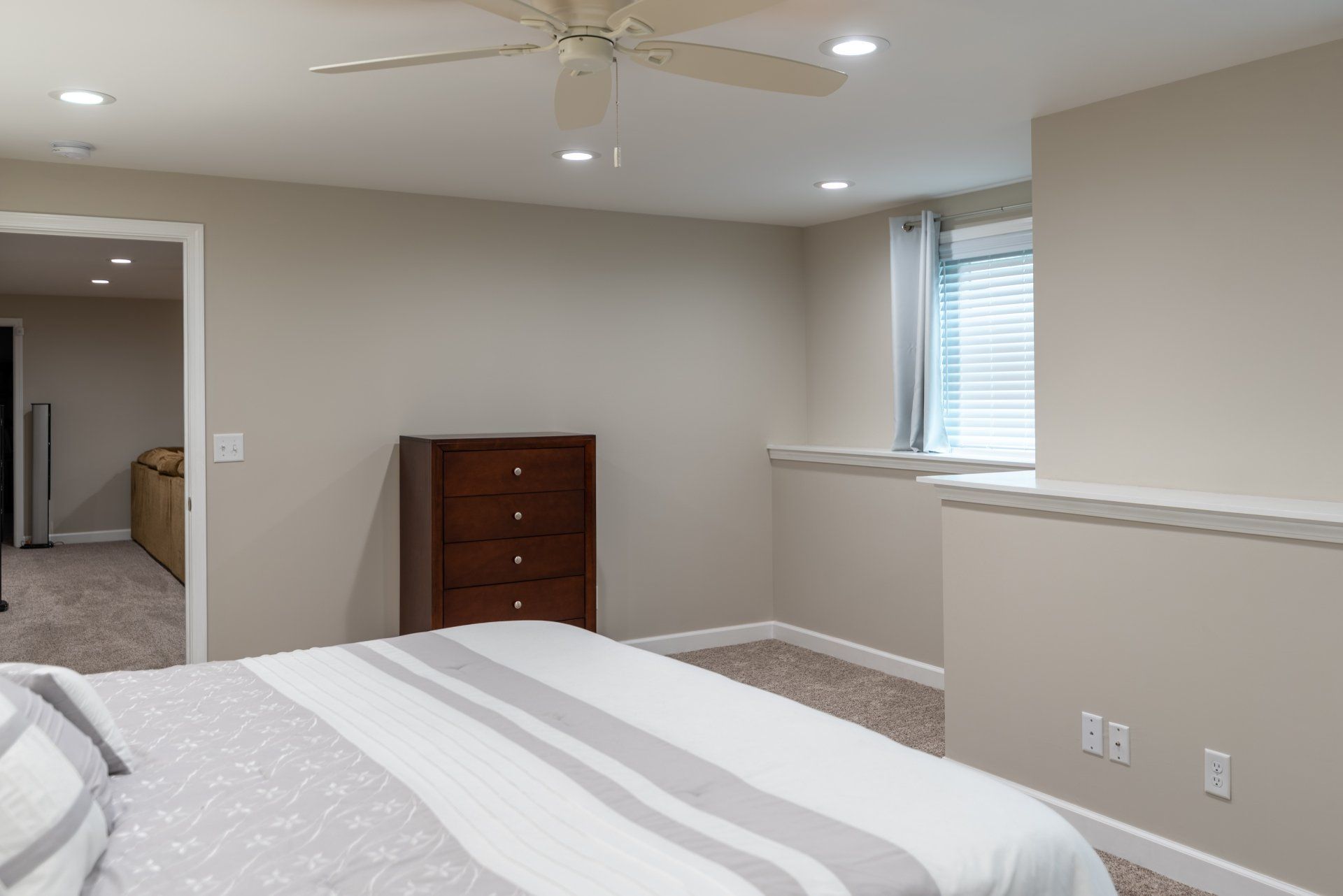 A bedroom with a large bed and a ceiling fan.
