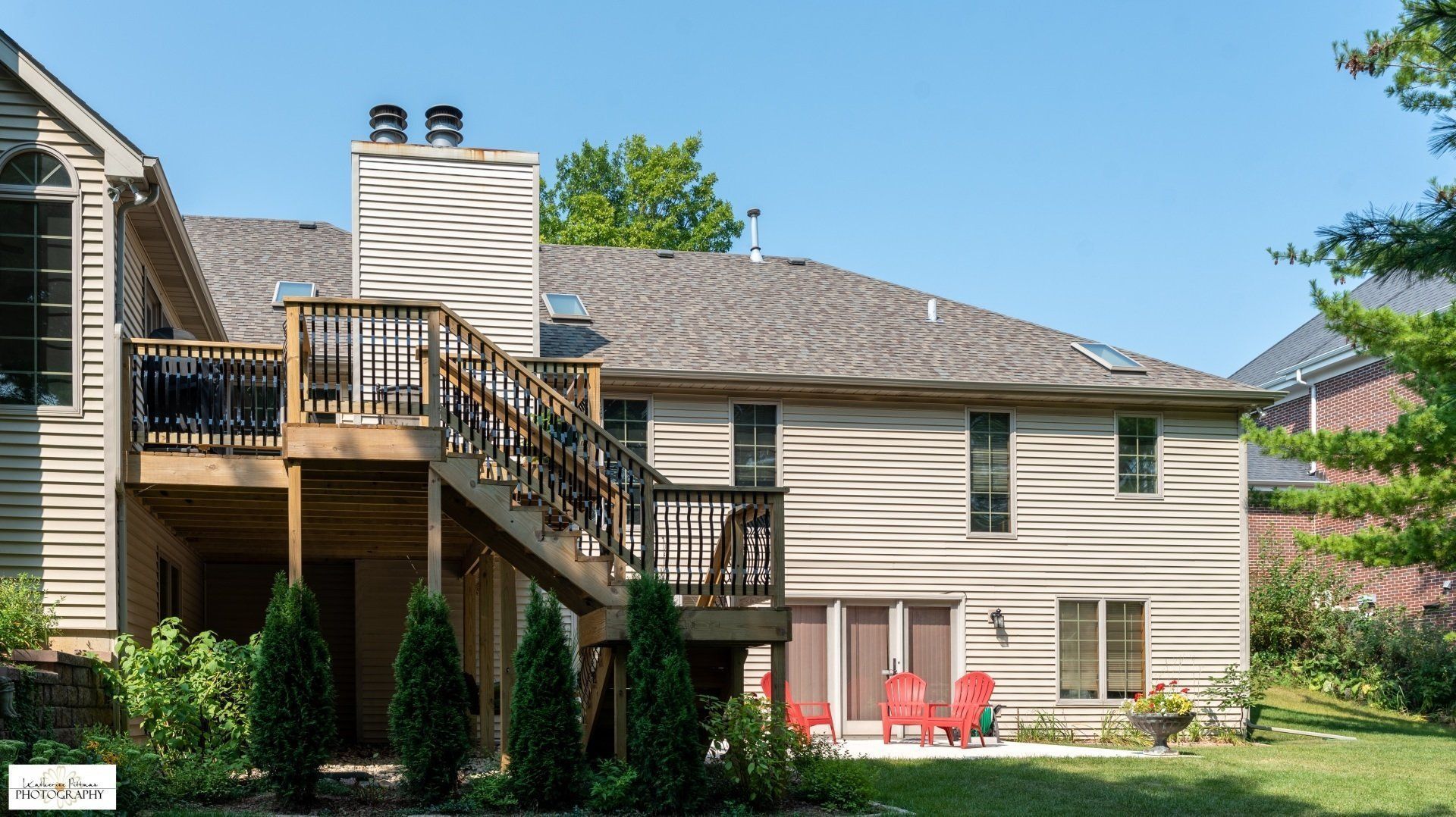 The back of a house with a large deck and stairs