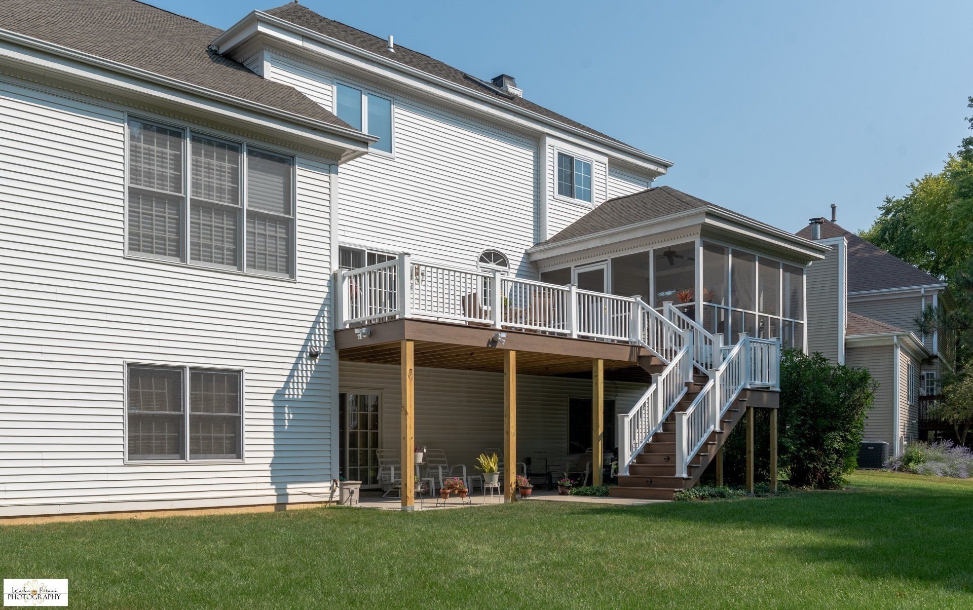 A large white house with a large deck and stairs
