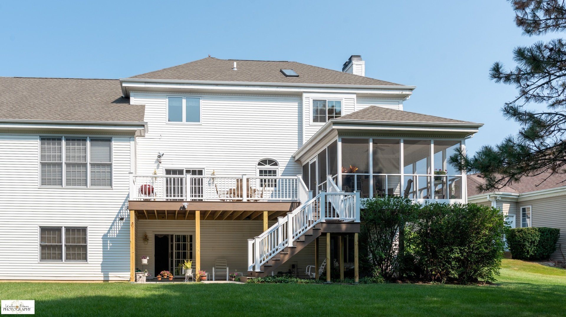 A white house with a screened in porch and stairs