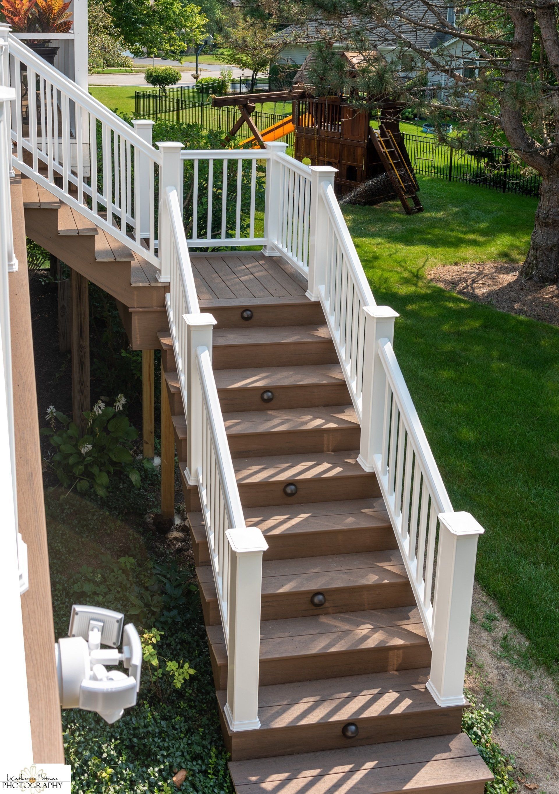 A set of stairs leading up to a deck with a white railing.