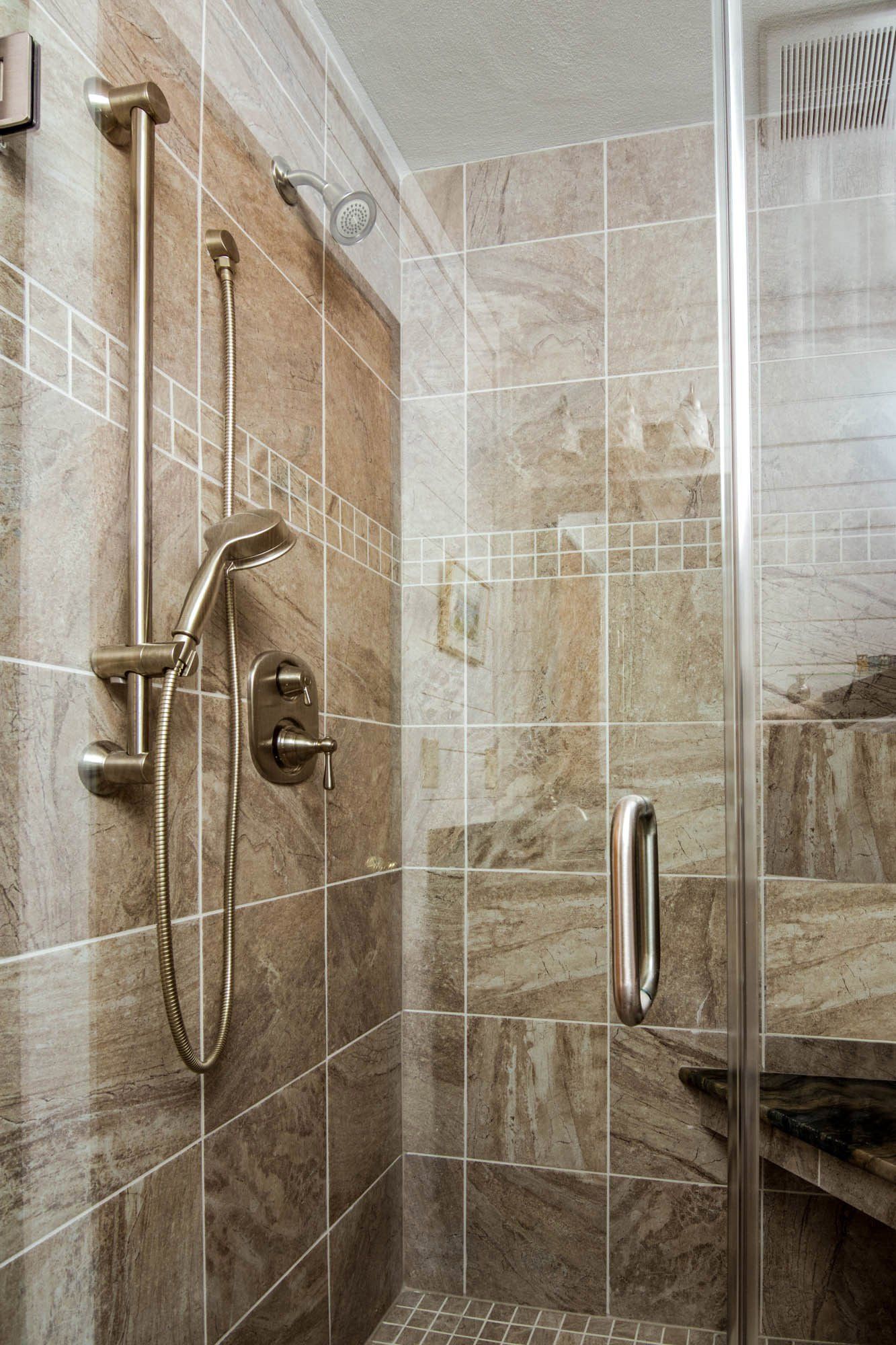 A bathroom with a walk in shower and a glass door.