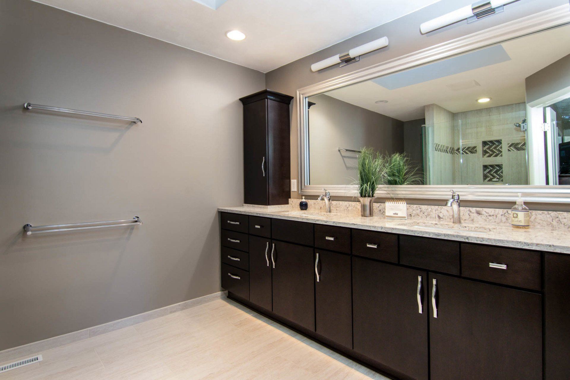 A bathroom with two sinks and a large mirror.