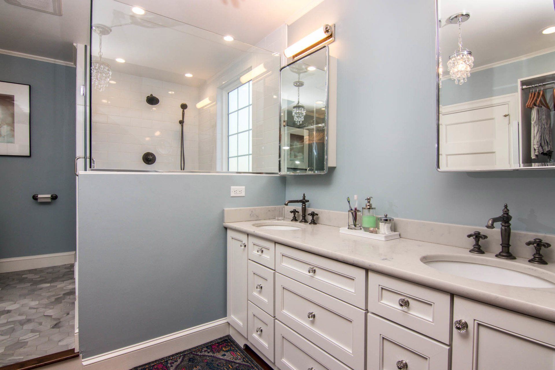 A bathroom with two sinks and a walk in shower.