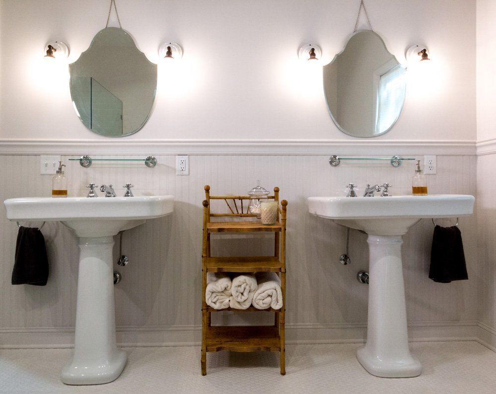A bathroom with two sinks and two mirrors