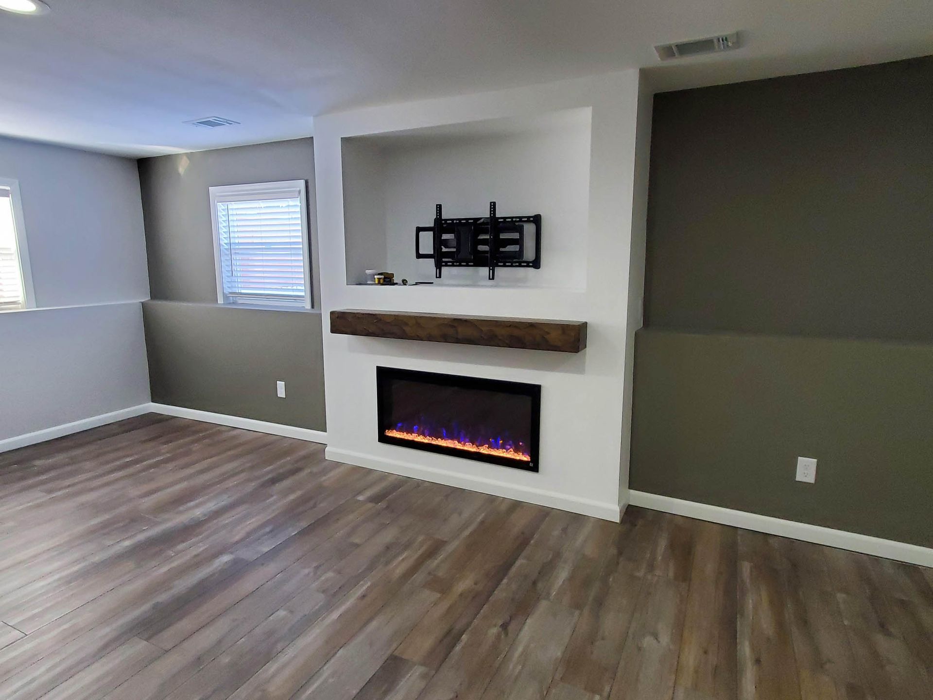 A living room with a fireplace and a flat screen tv mounted on the wall.