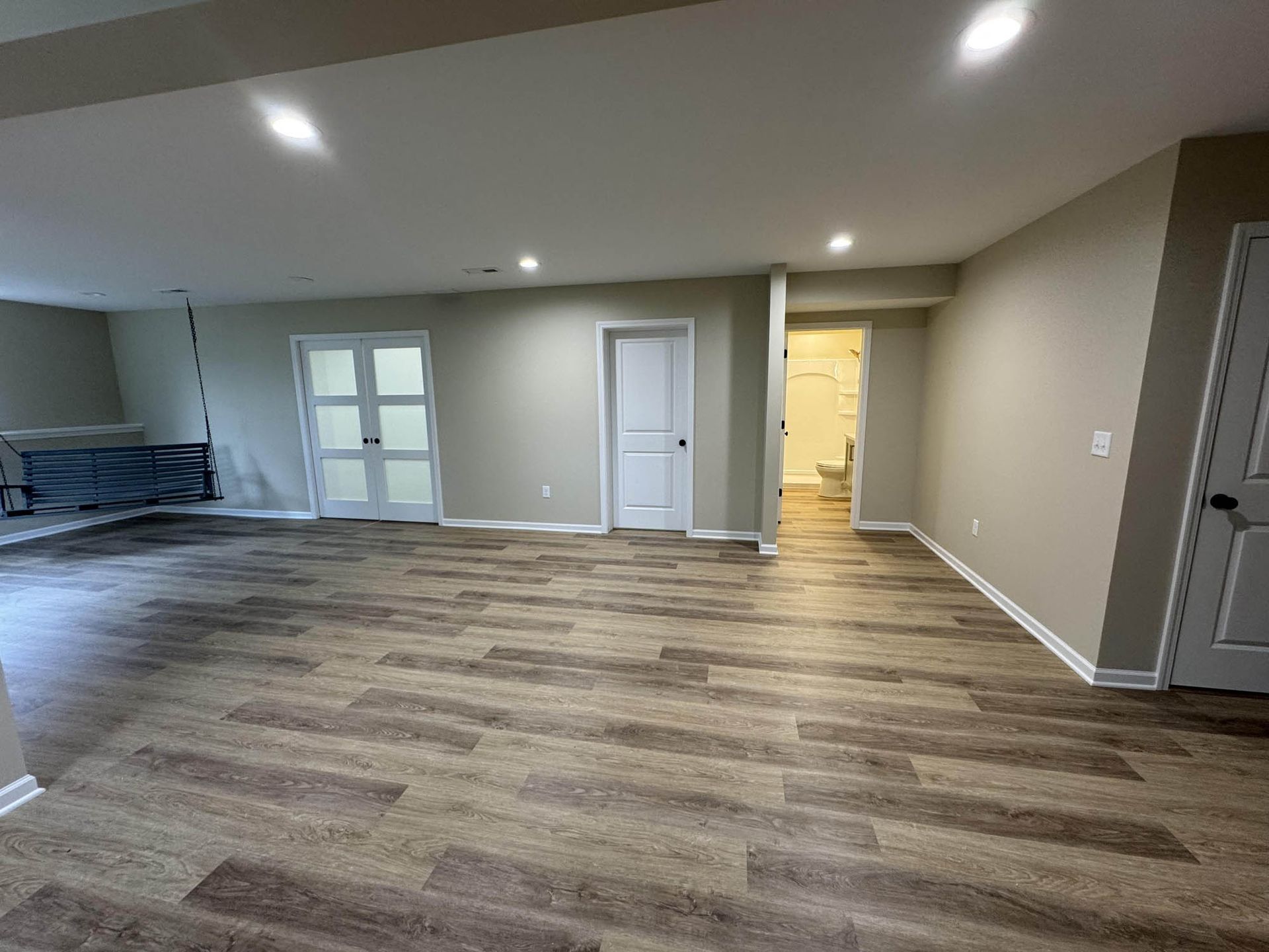 A large empty room with wooden floors and white walls.