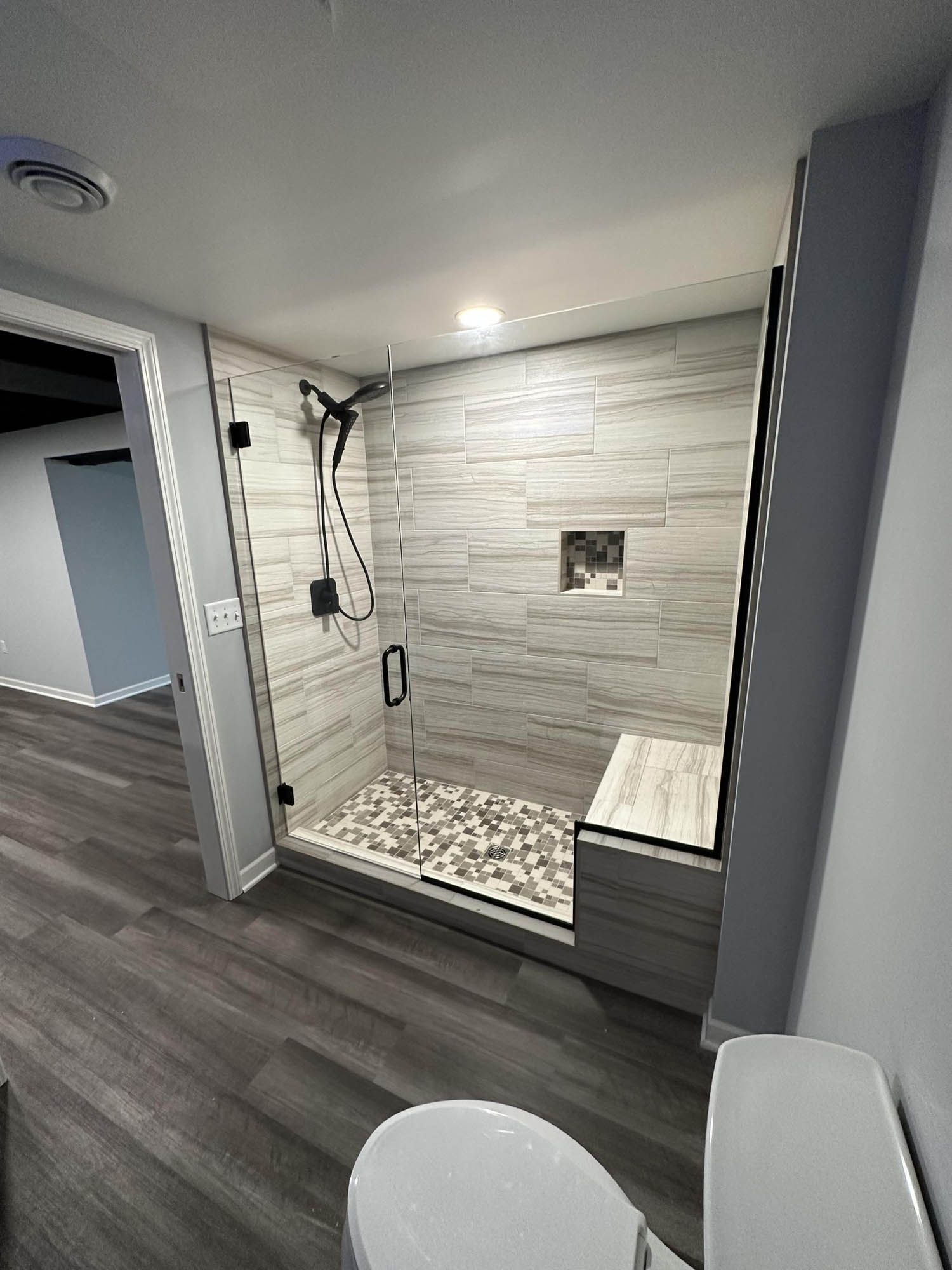 A bathroom with a walk in shower and a toilet.