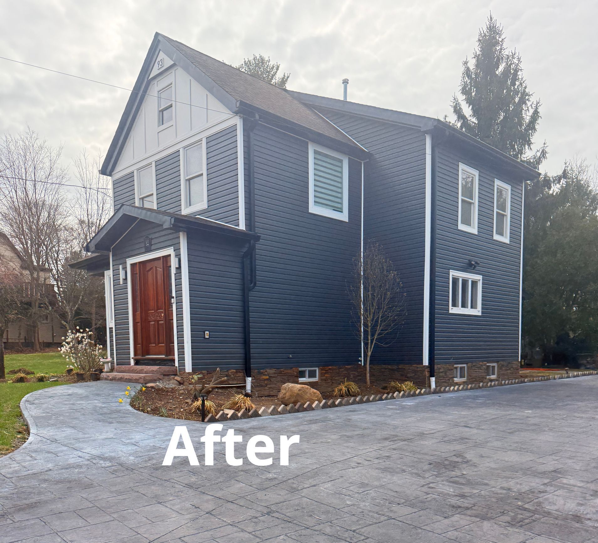 After: blue house with white trim beside a paved driveway and curved walkway