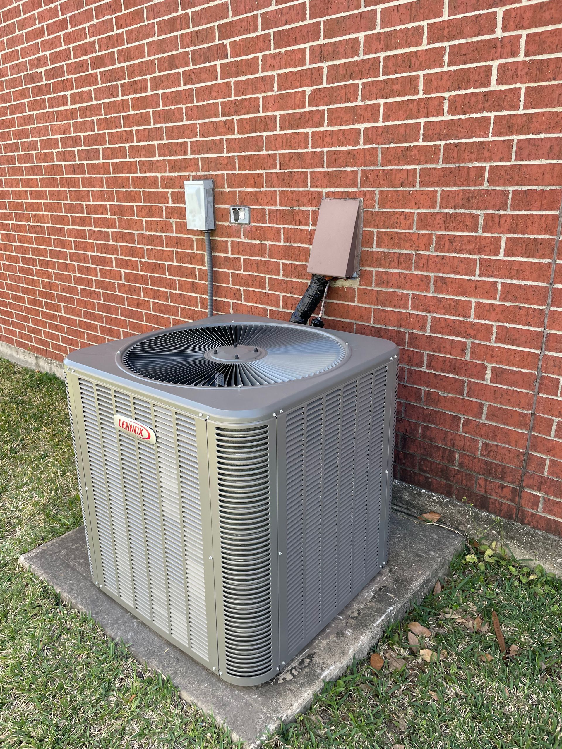 Central air conditioning unit outside a brick building.