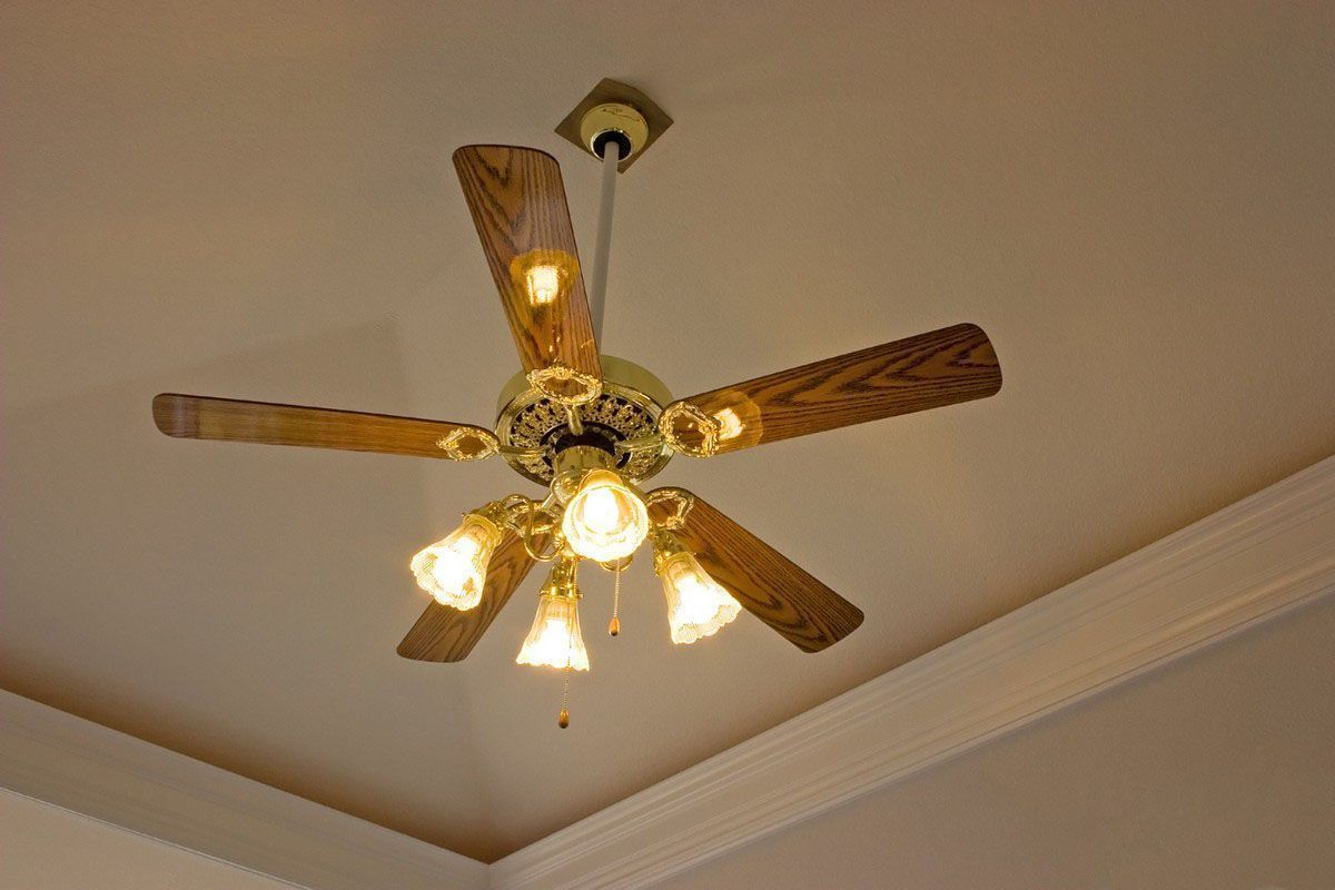 Wooden ceiling fan with light bulbs on a beige ceiling