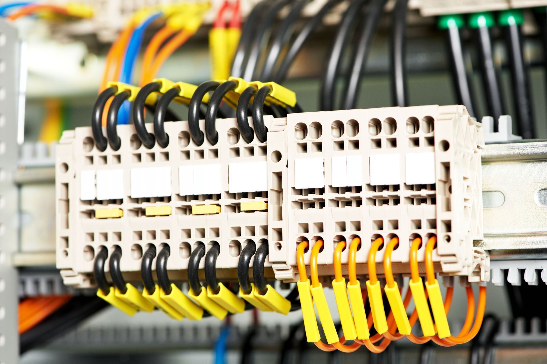 Electrical control panel with rows of terminal blocks and colorful wires connected.