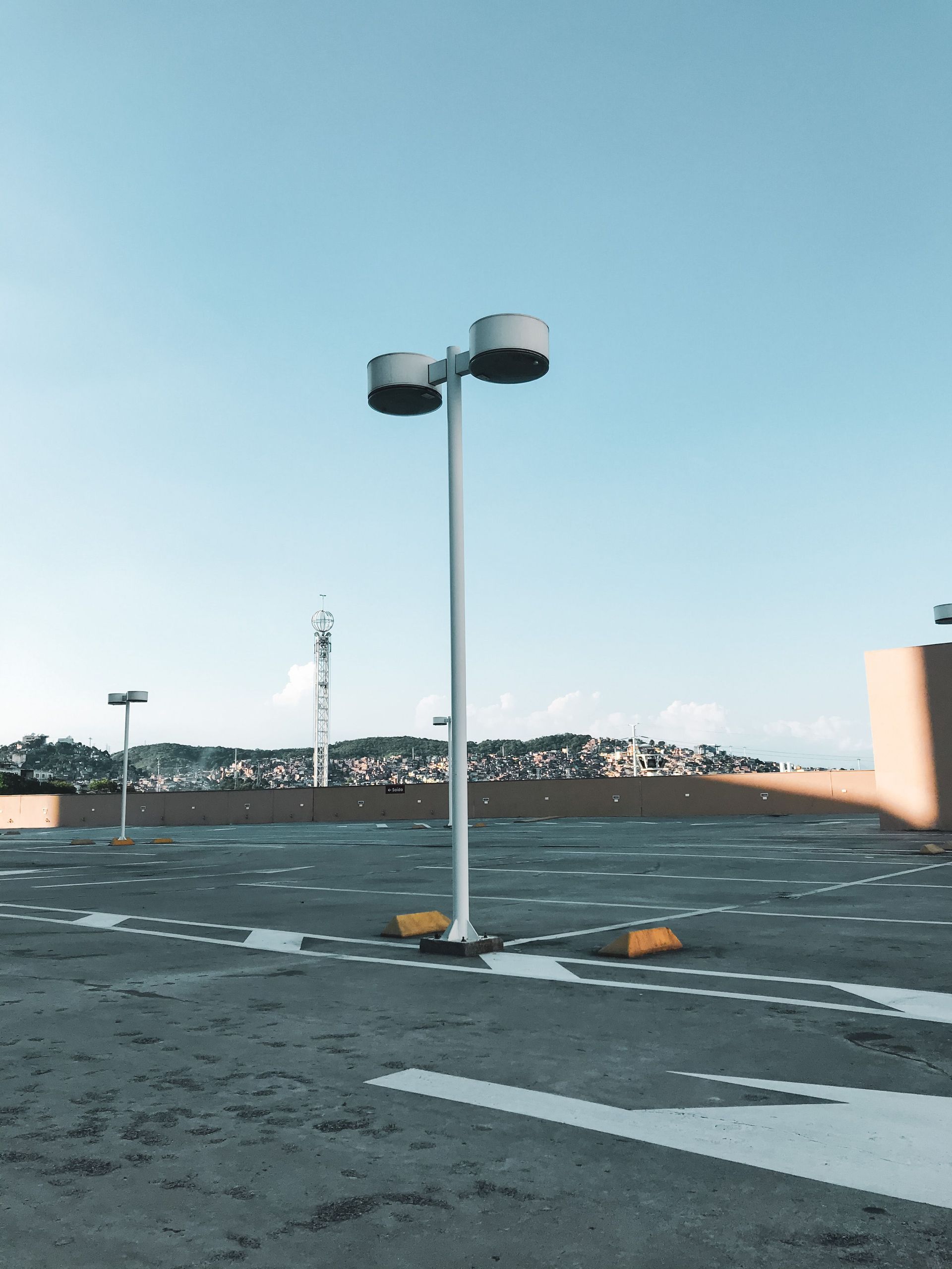 Empty rooftop with a tall light pole under a clear blue sky
