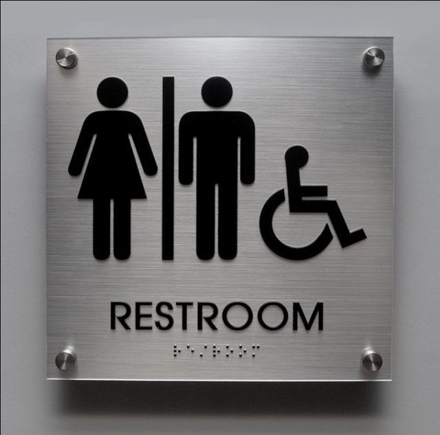 Metal restroom sign with male, female, and wheelchair symbols