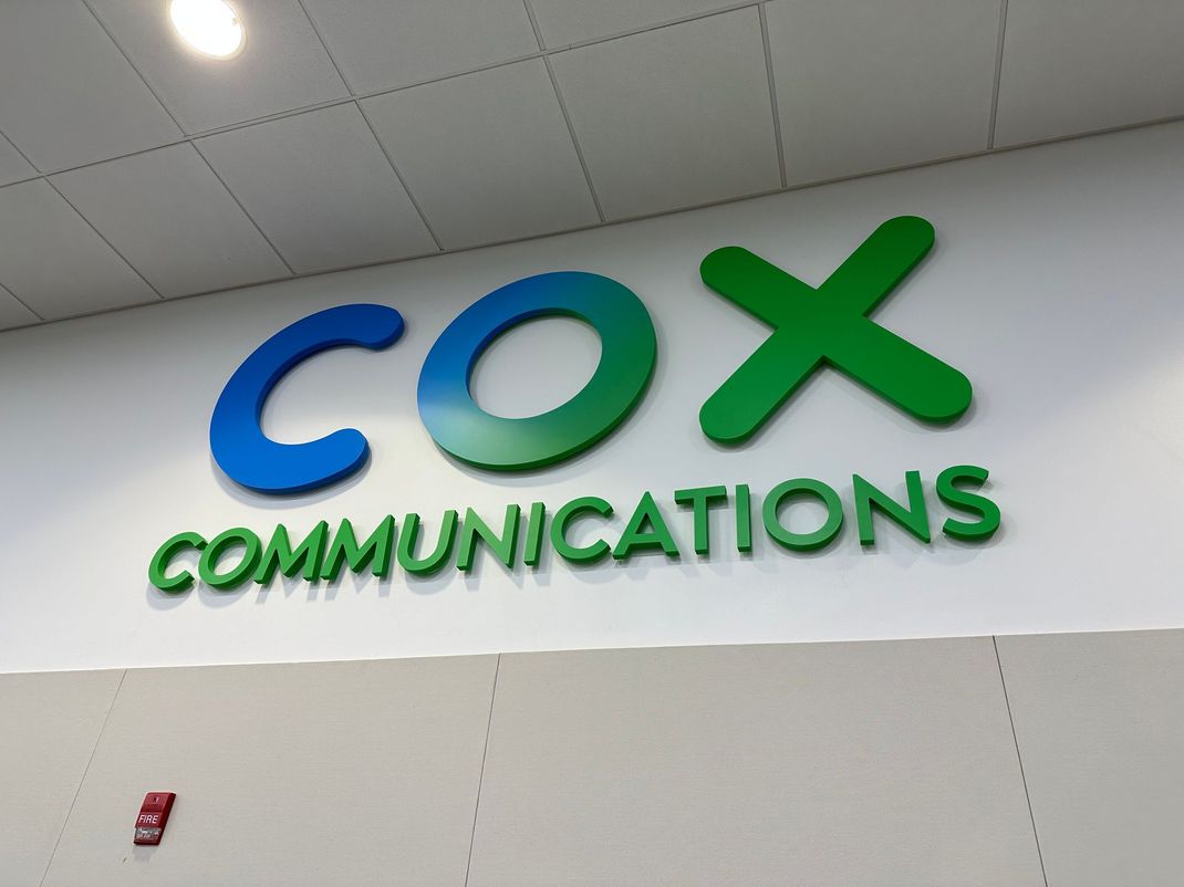 Cox Communications logo on a wall in a lobby