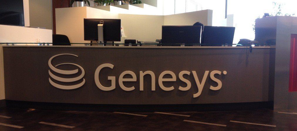 Genesys logo on a dark reception desk in an office lobby