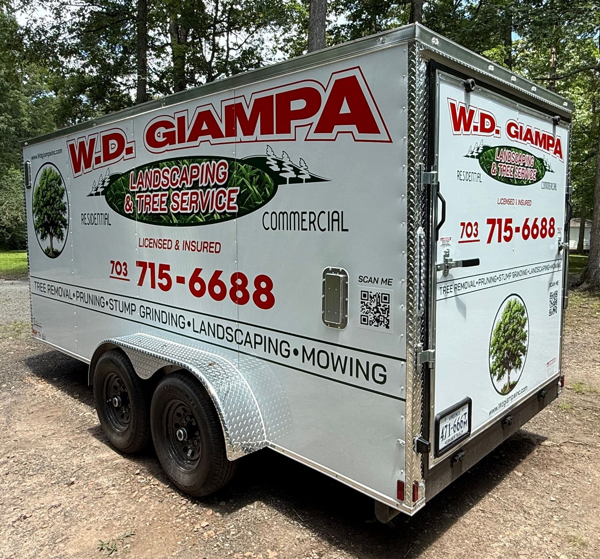 White landscaping trailer with W.D. Giampa logo and mowing service text, parked on dirt road outdoors