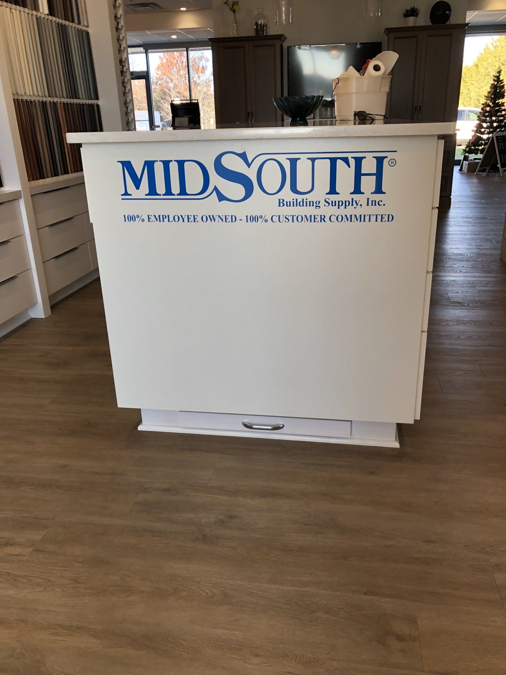 White Midsouth Industries booth display on a wood floor in an indoor lobby or showroom.